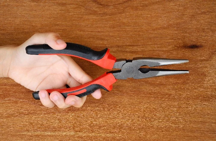 Hand hält eine Spitzzange